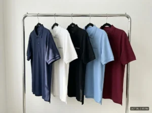 Polo shirt men custom manufacturing: cotton piqué fabric samples in multiple colors on factory table